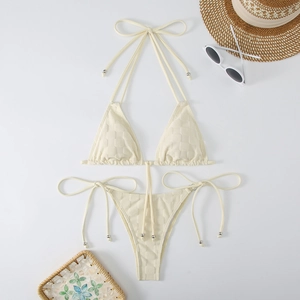 Macro detail of cream halter bikini with textured waffle fabric and strap metal beads