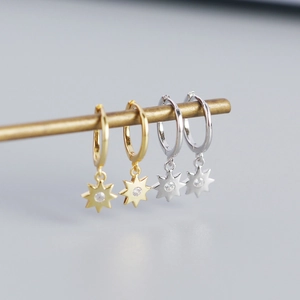 Detail of gold and silver S925 octagonal star earrings with crystal insets
