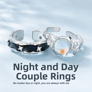 Detailed close-up of adjustable angel and demon couple rings with black enamel and moonstone