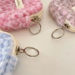 Dettaglio di borse in peluche leopardate in rosa, viola e blu con cerniere metalliche