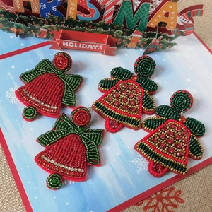 Detail view of handmade seed bead Christmas bell earrings with festive rhinestones