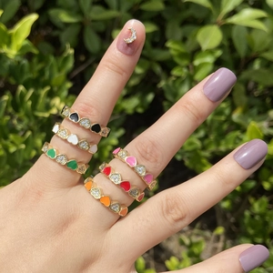Detail of colorful enamel heart rings with sparkling zircon accents on model's hand
