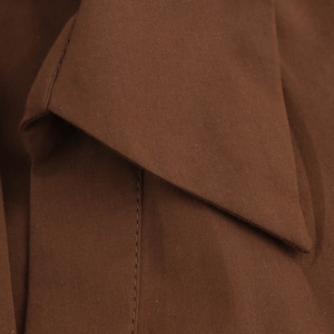 Close-up of V-neckline and fabric texture on dark brown poplin blouse for women