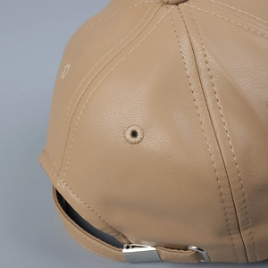 Detail of premium PU leather baseball cap showing stitching and metal adjustment buckle