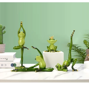 Detailed set of four green yoga frog figurines on a white marble table