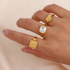 Detailed view of gold rings set featuring white zircon, elephant design and 111 engraving