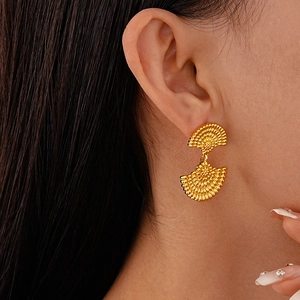 Vintage gold fan-shaped geometric earrings with textured metal finish on a model