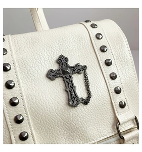 Detail of white litchi pattern PU leather backpack featuring gothic metal cross and rivets