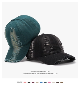 Detail showing distressed torn cotton texture on dark green and black baseball caps