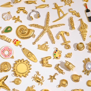 Collection of golden ocean-themed stainless steel charms including starfish and shells