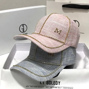 Pink and blue tweed baseball caps with rhinestone edges and golden metal M lettering