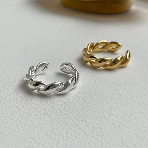 Macro detail of S925 sterling silver twisted rope rings in silver and gold finishes