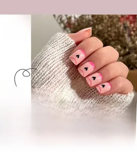 Faux ongles courts carrés, base rose, pointes French rose foncé et motifs cœurs noirs
