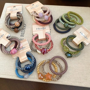 Detail view of colorful spiral telephone cord hair ties with heart and star pendants