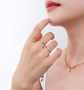 Detail of minimalist gold-plated rings and dainty star pendant necklace on model