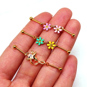Gros plan de barbells industriels dorés avec des fleurs en émail et des pierres claires