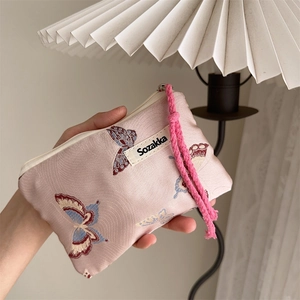 Detailed macro shot of jacquard butterfly pattern and brand label on a pink woven bag