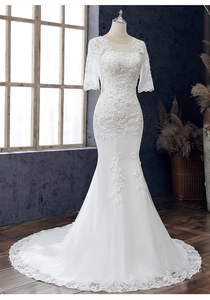 Detailansicht der aufwendigen Spitzenstickerei an der Schleppe des weißen Hochzeitskleids