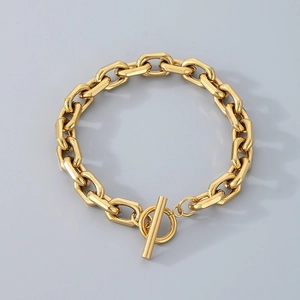 Polished gold stainless steel OT buckle chain bracelet with oval links on grey background