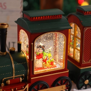 Detail of Christmas locomotive music box with sparkling glitter water globe and snowman