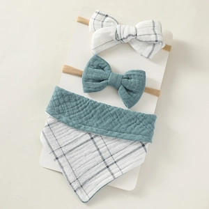 Detailed view of baby bib set with blue gingham muslin and nylon bow headbands