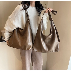 Detailed view of brown soft leather tote bag showing spacious design and slouchy texture