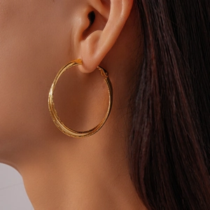 Close-up of 18k gold plated double cross hoop earrings with textured matte finish