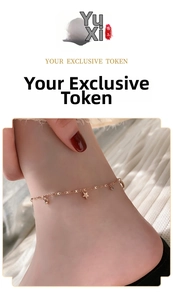 Close-up of rose gold star and crystal charms on a slim stainless steel anklet