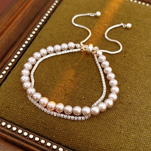 Gros plan du bracelet double rangée avec perles et zircons sur plateau en velours