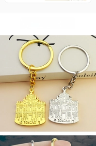 Detail of gold and silver Macau Ruins of St. Paul's keychains with embossed souvenir texture