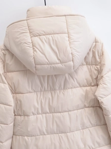 Detailed back view of a beige quilted padded jacket featuring a thermal hood and smooth seams