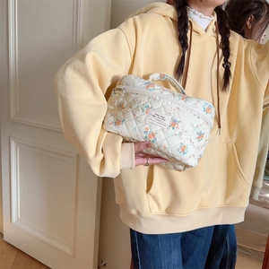 Détail de la trousse de toilette matelassée à fleurs avec double fermeture éclair