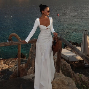 Detail of white long-sleeve cutout dress with slim fit for beach vacation at sunset