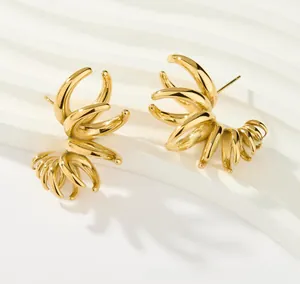 Macro shot of gold-plated titanium earrings with creative multi-claw organic streamline design