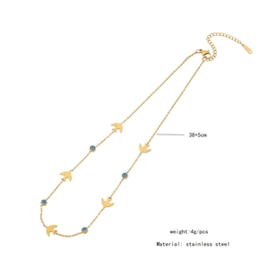 Detail view of double-layer stainless steel necklace with blue evil eye and gold bird charms