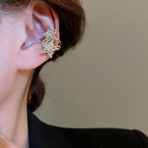 Detailed close-up of a double-layered gold star ear cuff with sparkling zircon stones