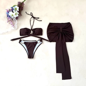 Three-piece chocolate brown bikini with golden metal rings and matching bow skirt