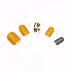 Detail of round press-on nails with mustard yellow and grey floral hand-painted designs