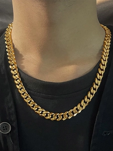 Close-up of golden stainless steel Cuban link necklace worn on model for length view