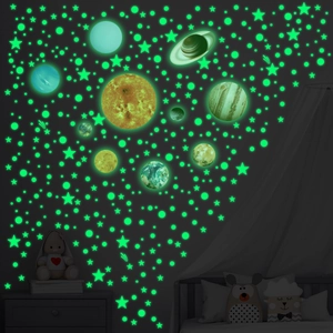 Luminous solar system wall stickers glowing green with planets and stars in a dark room