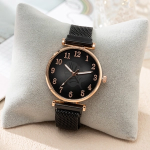 Fashionable women's watch with black mesh strap and rose gold case on velvet cushion