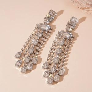 Vue détaillée de boucles d'oreilles géométriques argentées avec franges en cristal