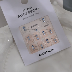 Detailed view of silver-edged nail charms with blue rhinestones on MJ-065 display card
