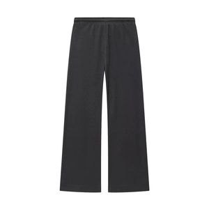 Detailed view of black soft knit wide-leg trousers featuring a comfortable elastic waistband