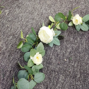 Macro detail of artificial white roses and green money leaf eucalyptus floral garland