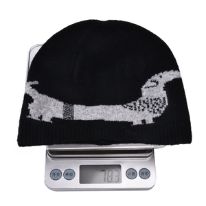 Detail shot of black knitted beanie weight at 78.3g showing the dachshund jacquard pattern