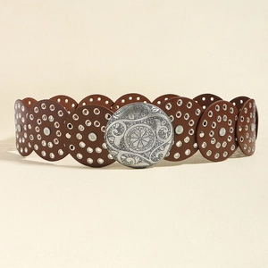 Dettaglio di cintura vintage western marrone con dischi metallici traforati e fibbia decorata