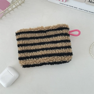Close-up of brown and black striped plush mini pouch with a vibrant pink zipper puller