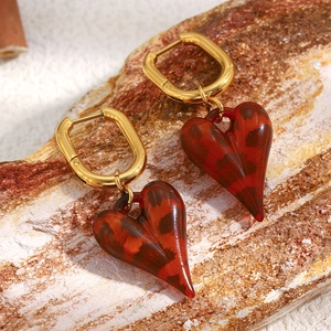 Dettaglio di orecchini a U placcati oro 18K con pendenti a cuore in acrilico tartarugato
