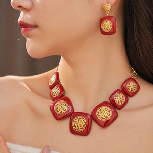 Primo piano dettagliato di un set vintage con collana e orecchini in smalto rosso